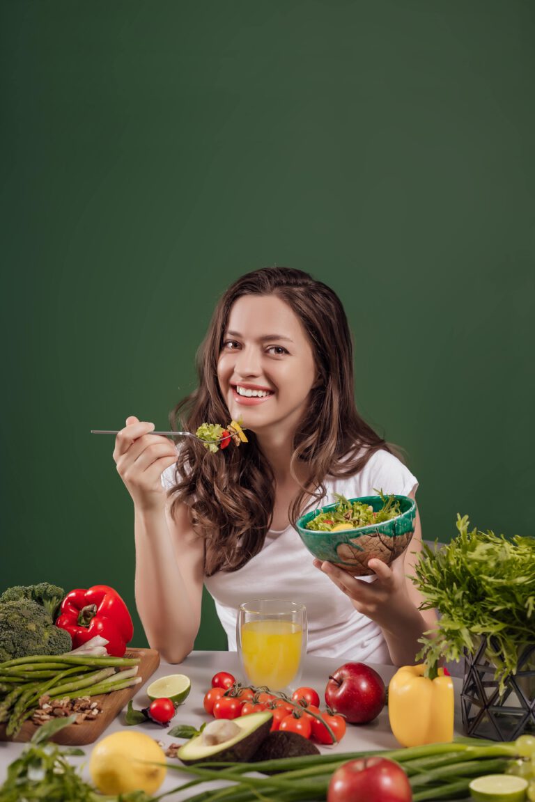 young-woman-eating-healthy-food-green-background-min