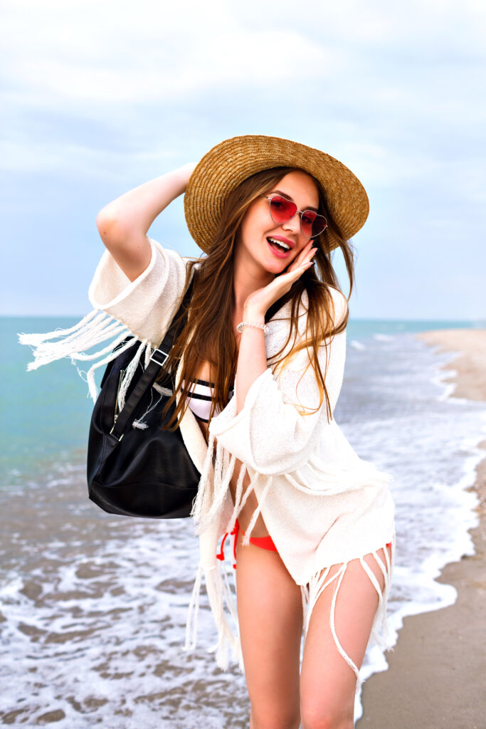 young-woman-having-fun-lonely-beach-enjoy-summer-vacation-relax-boho-outfit-straw-hat-bikini